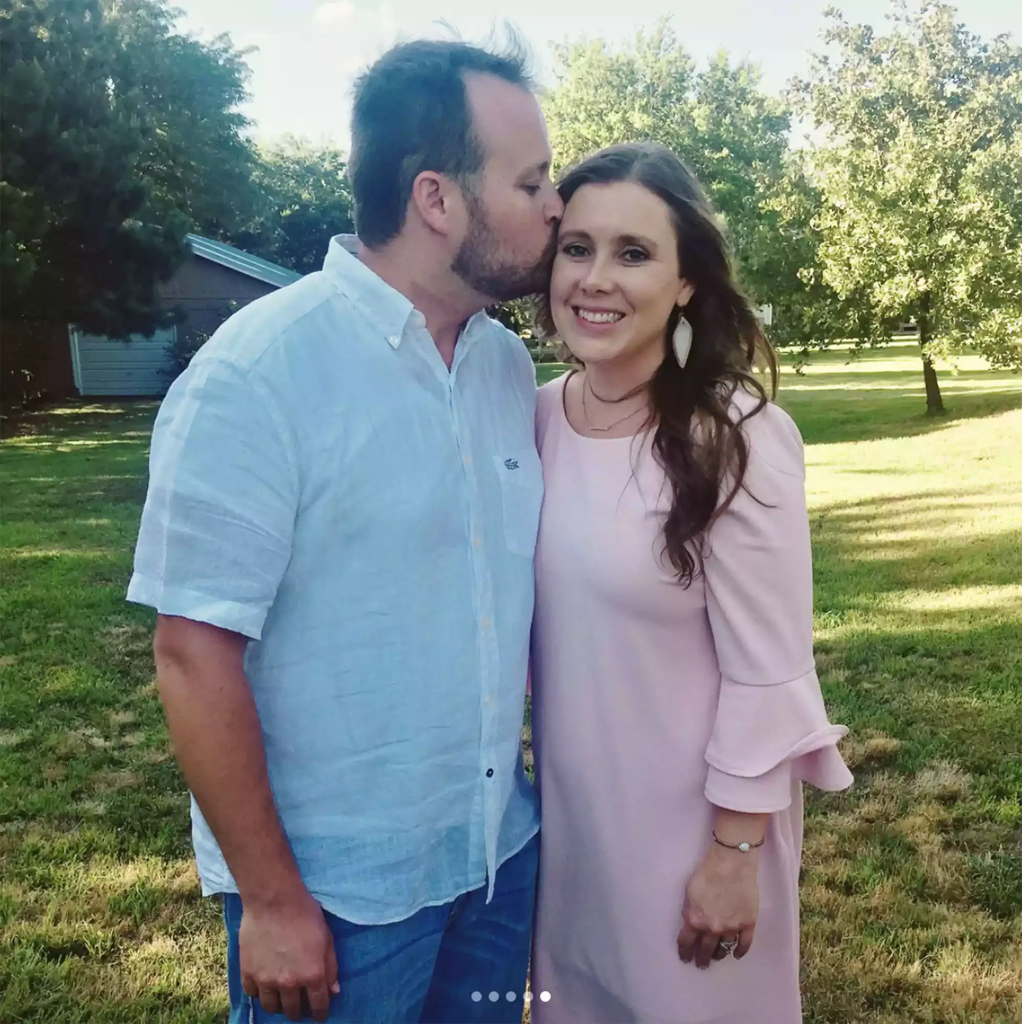 Josh Duggar kissing Anna Duggar on the cheek in an outdoor setting.