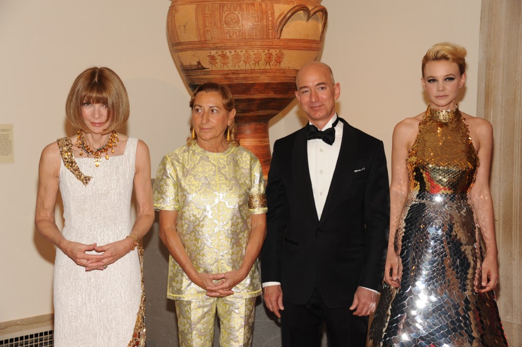 Anna Wintour, in a white dress, Miuccia Prada, in a gold pant suit, Jeff Bezos, in black tie, and Carey Mulligan, in a metallic halter neck gown, at the Metropolitan Museum of Art’s 2012 Costume Institute Gala.