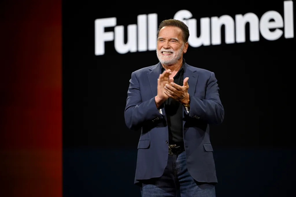 Arnold Schwarzenegger clapping onstage at the Amazon Upfront.