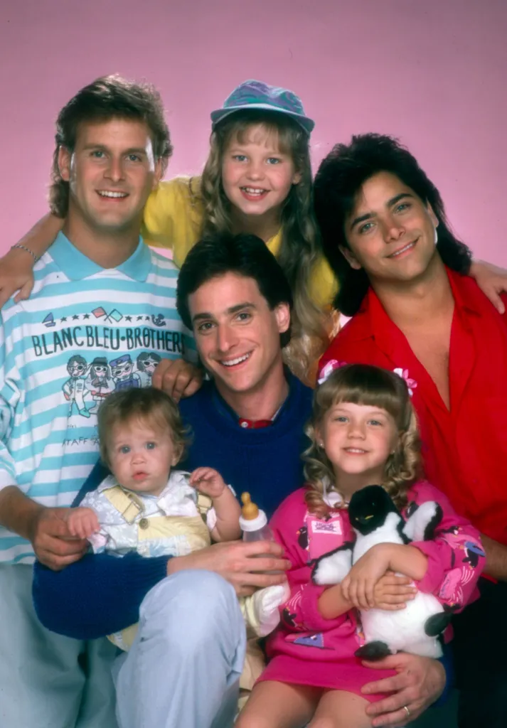 Cast photo of the television show Full House, featuring Dave Coulier, Candace Cameron, John Stamos, Jodie Sweetin, Bob Saget, and Ashley/Mary-Kate Olsen.