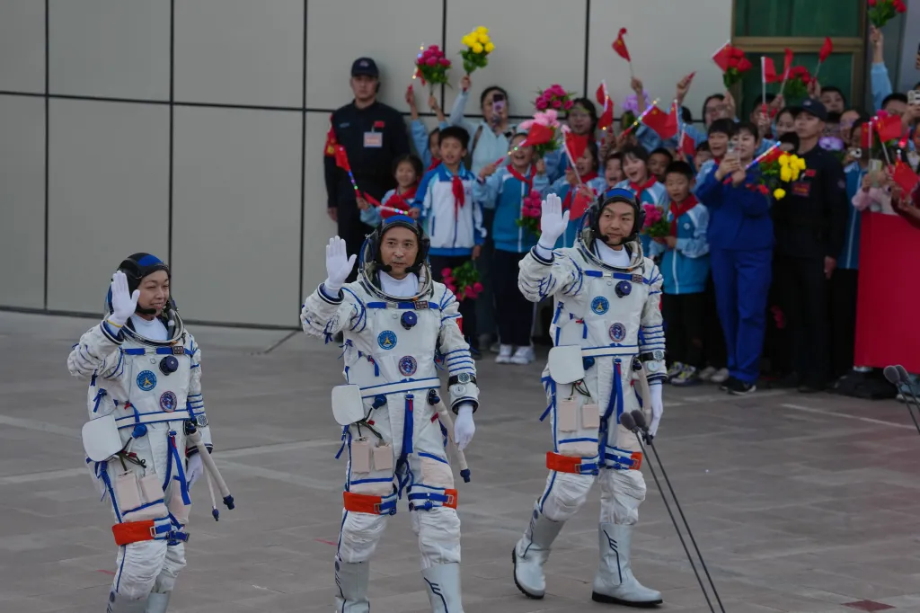 Li Jiaying, Zhu Yangzhu, and Zhang Zhiyuan wave at a send-off ceremony for the Shenzhou 23 manned space mission.
