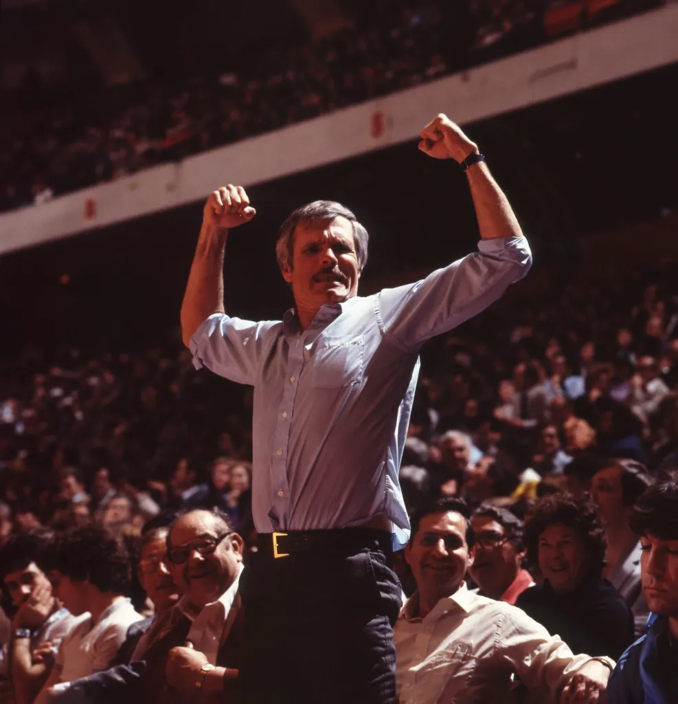 Atlanta Hawks owner Ted Turner flexes during a basketball game.