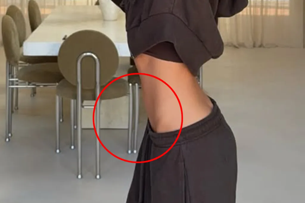 A close-up of a woman's midriff with a red circle highlighting the bent legs of a chair behind her, indicating photo manipulation.