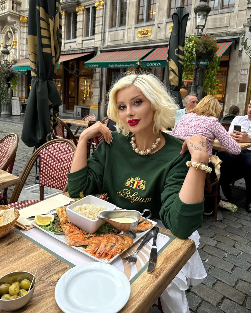 Aysegul Eraslan sitting at an outdoor restaurant table with a plate of shrimp and rice.