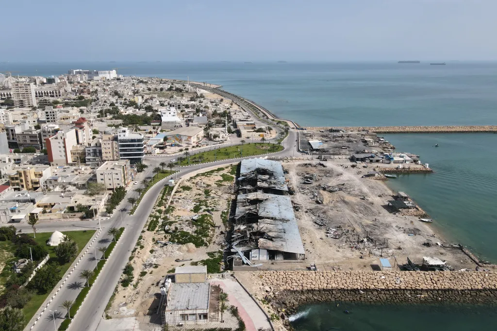 Aerial view of the port of Qeshm island, Iran, showing widespread damage to buildings and the pier from recent airstrikes.