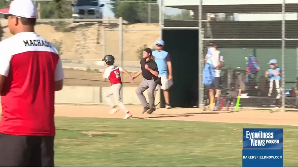 Umpire Sawyer Sparks running after a child in a baseball game.