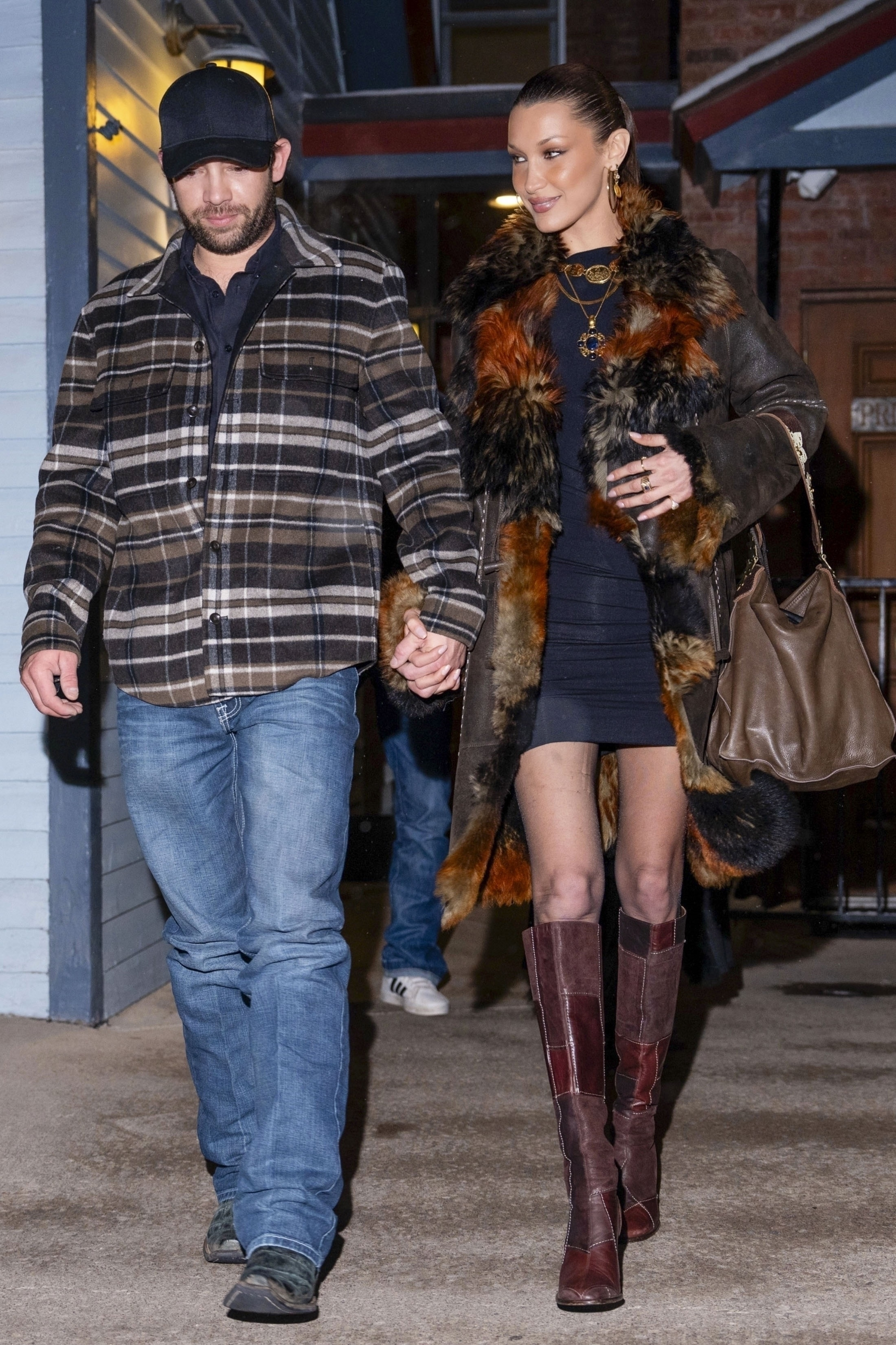 Bella Hadid and Adan Banuelos holding hands and smiling while leaving a dinner date in Aspen.