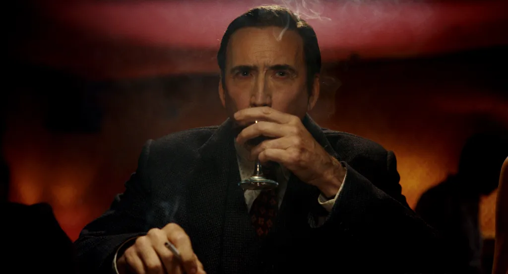 Nicolas Cage as Ben Reilly, drinking from a glass and holding a cigarette.