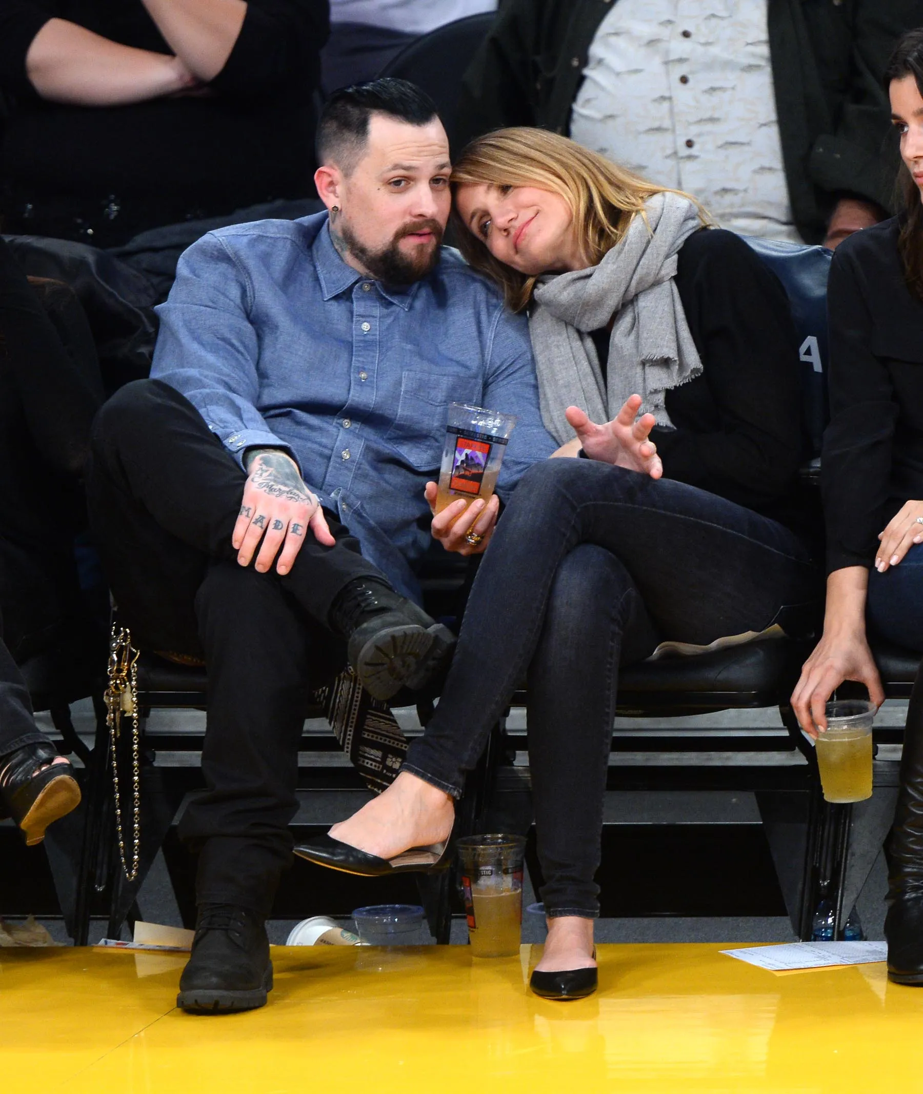 Benji Madden and Cameron Diaz sitting court side at a basketball game.