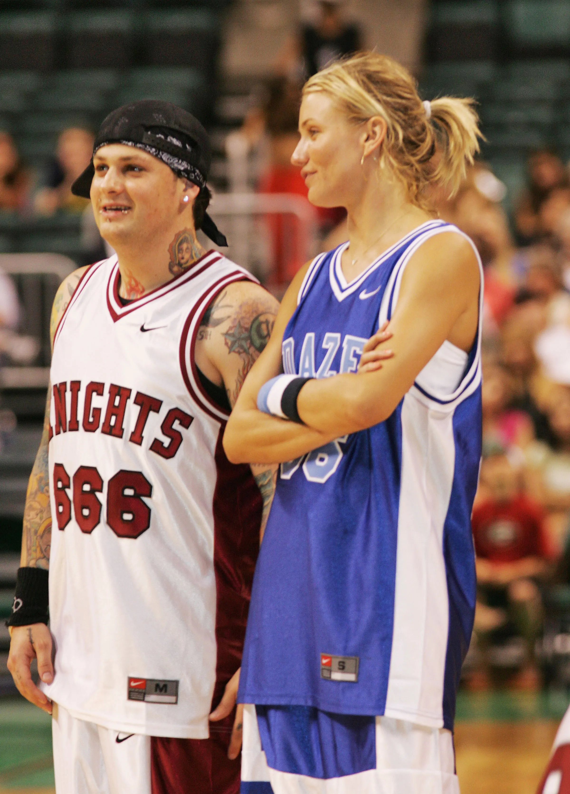 Benji Madden and Cameron Diaz in basketball jerseys on a court.