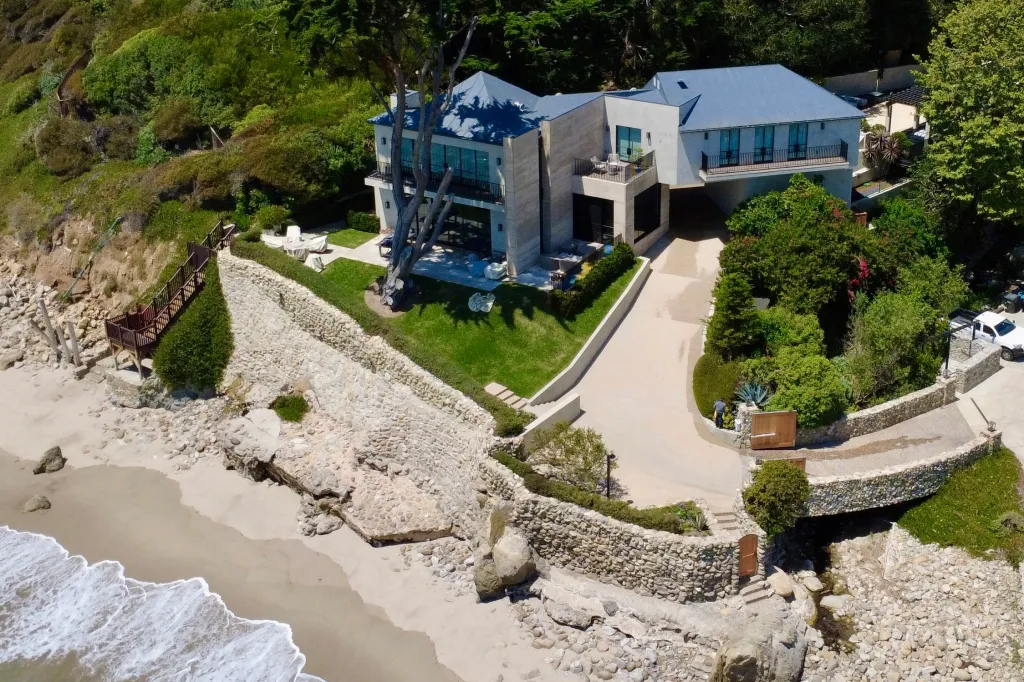 Aerial view of Daniel Nadler's mansion at 33014 Pacific Coast Highway, Malibu, CA, with a stone retaining wall and a white truck.