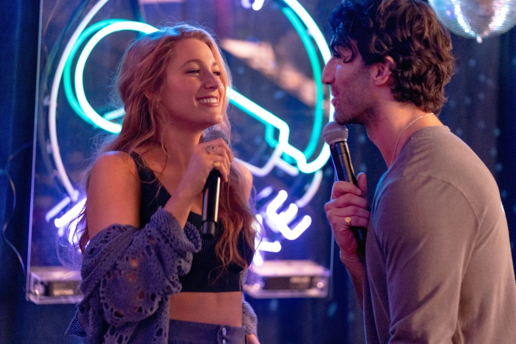 Blake Lively and Justin Baldoni singing into microphones.