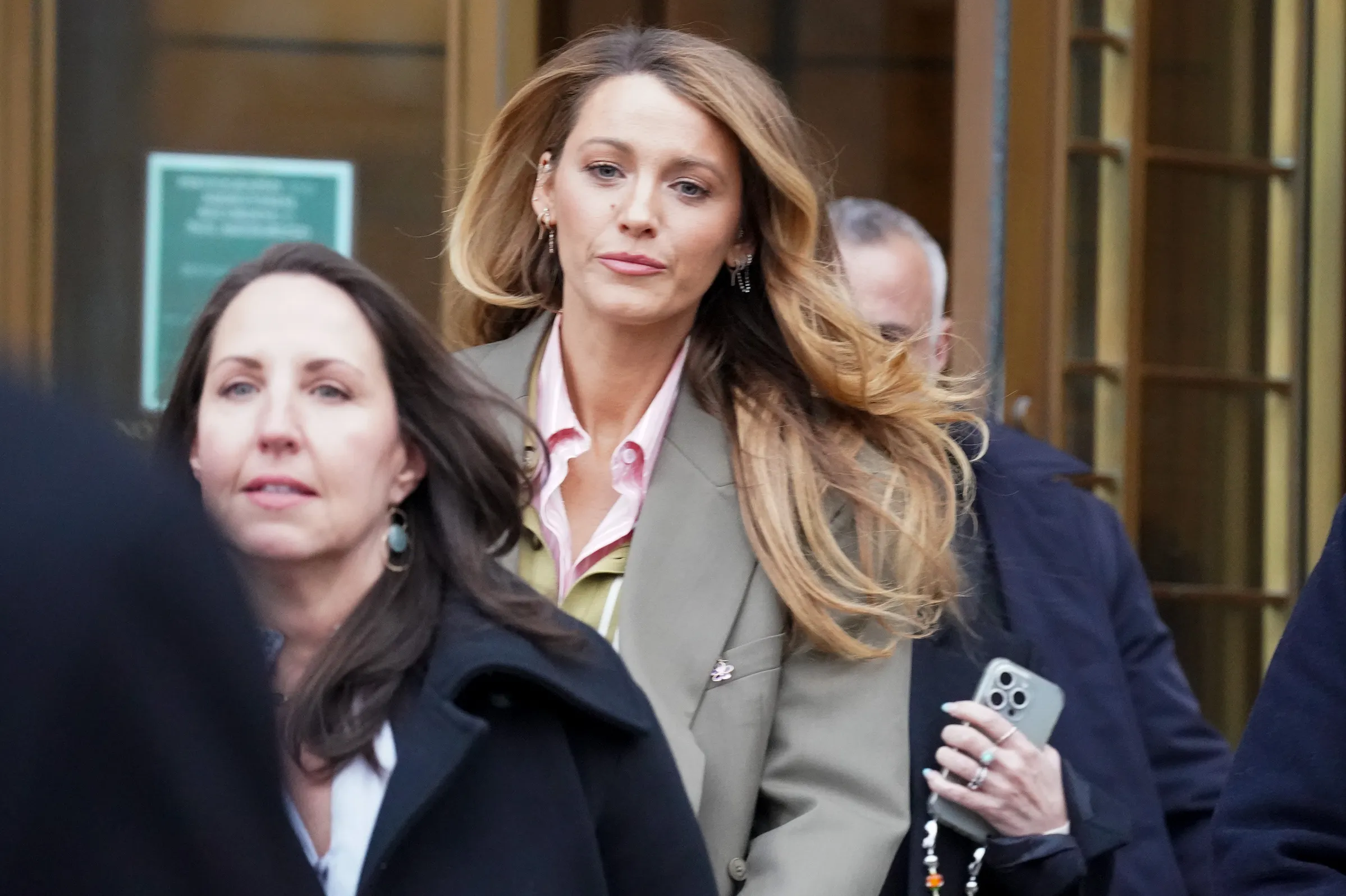 Blake Lively leaving Federal Court in a khaki blazer and pink shirt.