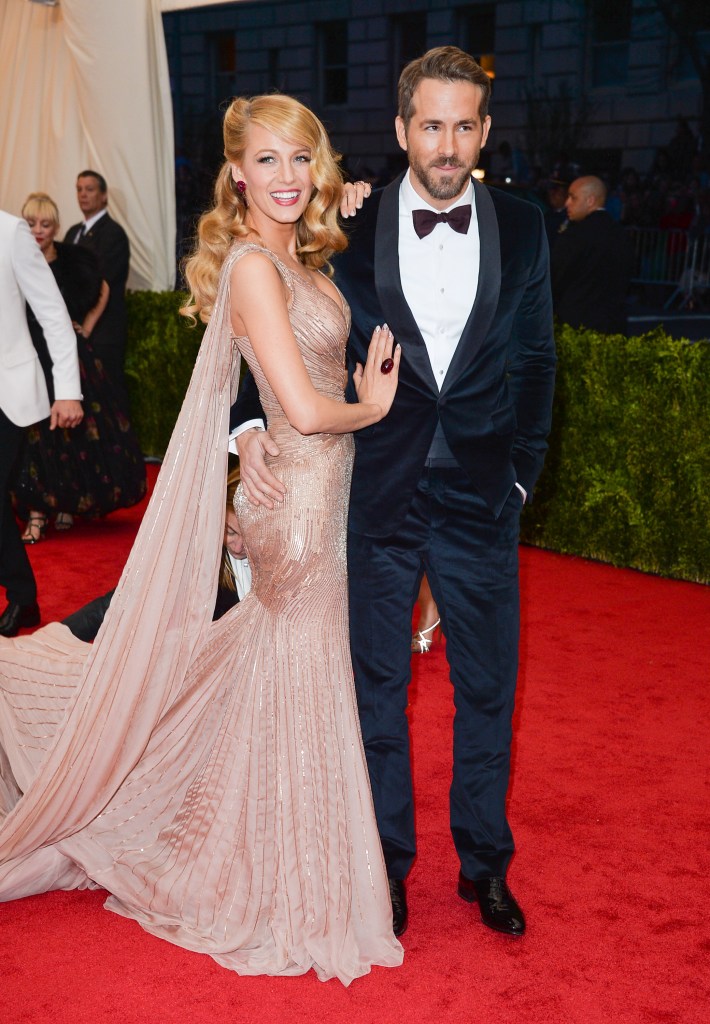 Blake Lively in a sparkling peach dress and Ryan Reynolds in a black tuxedo on a red carpet.