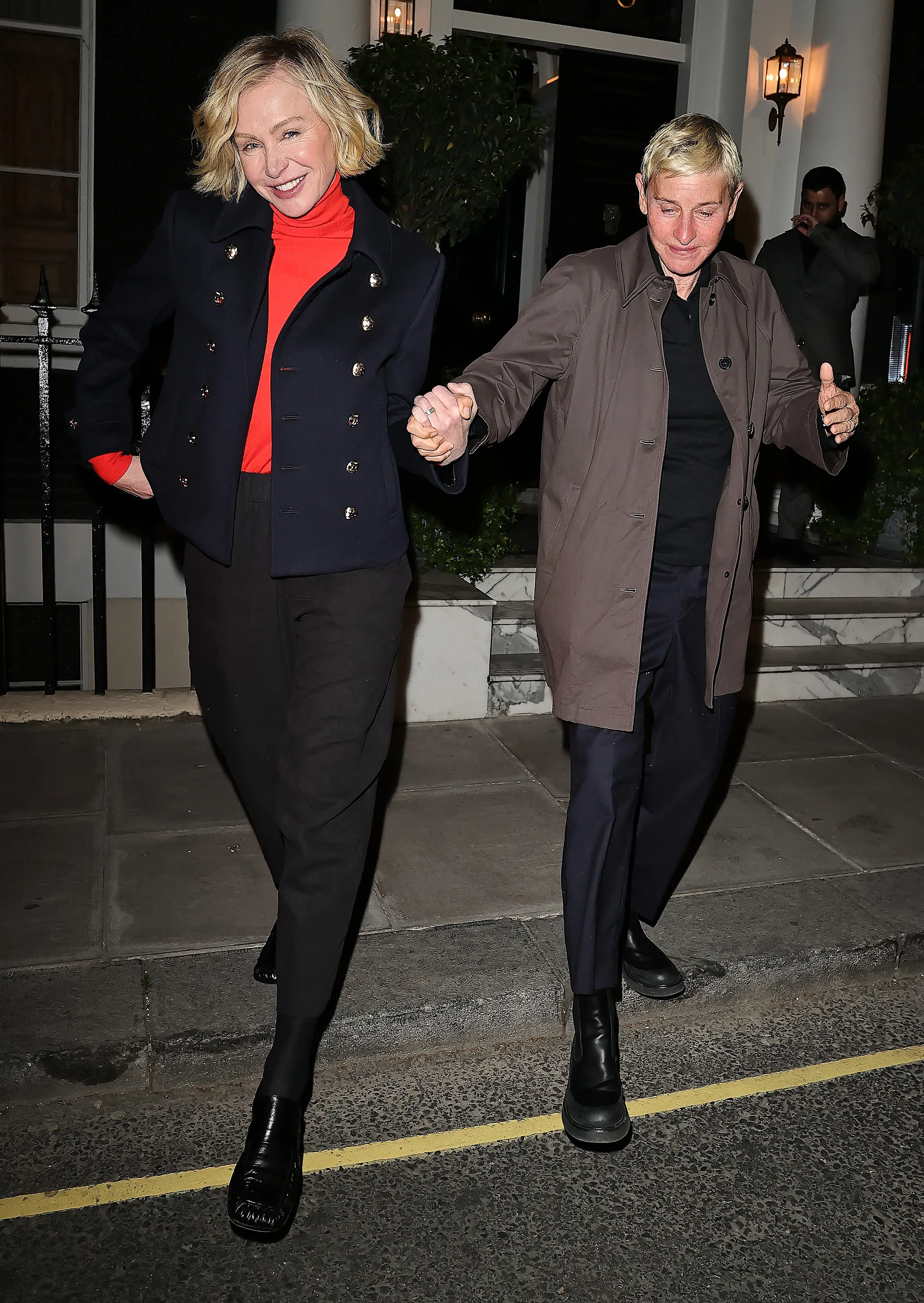 Portia de Rossi holding Ellen DeGeneres' hand as they leave a London restaurant.