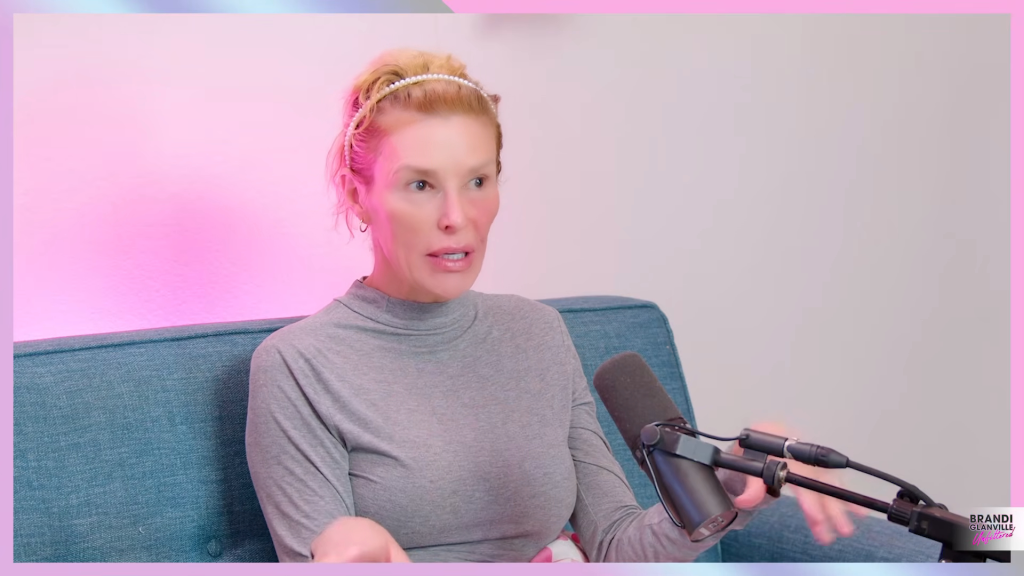Brandi Glanville speaking into a microphone.