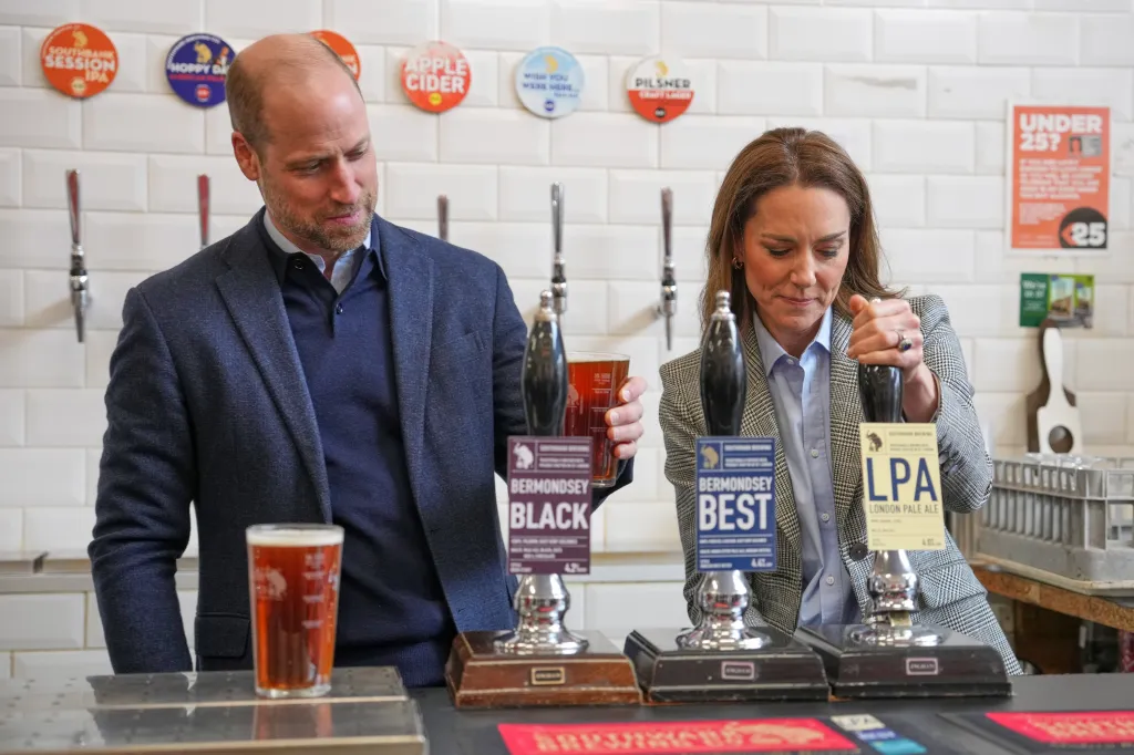 Prince William holding a beer next to Catherine, Princess of Wales, who is operating a beer tap.