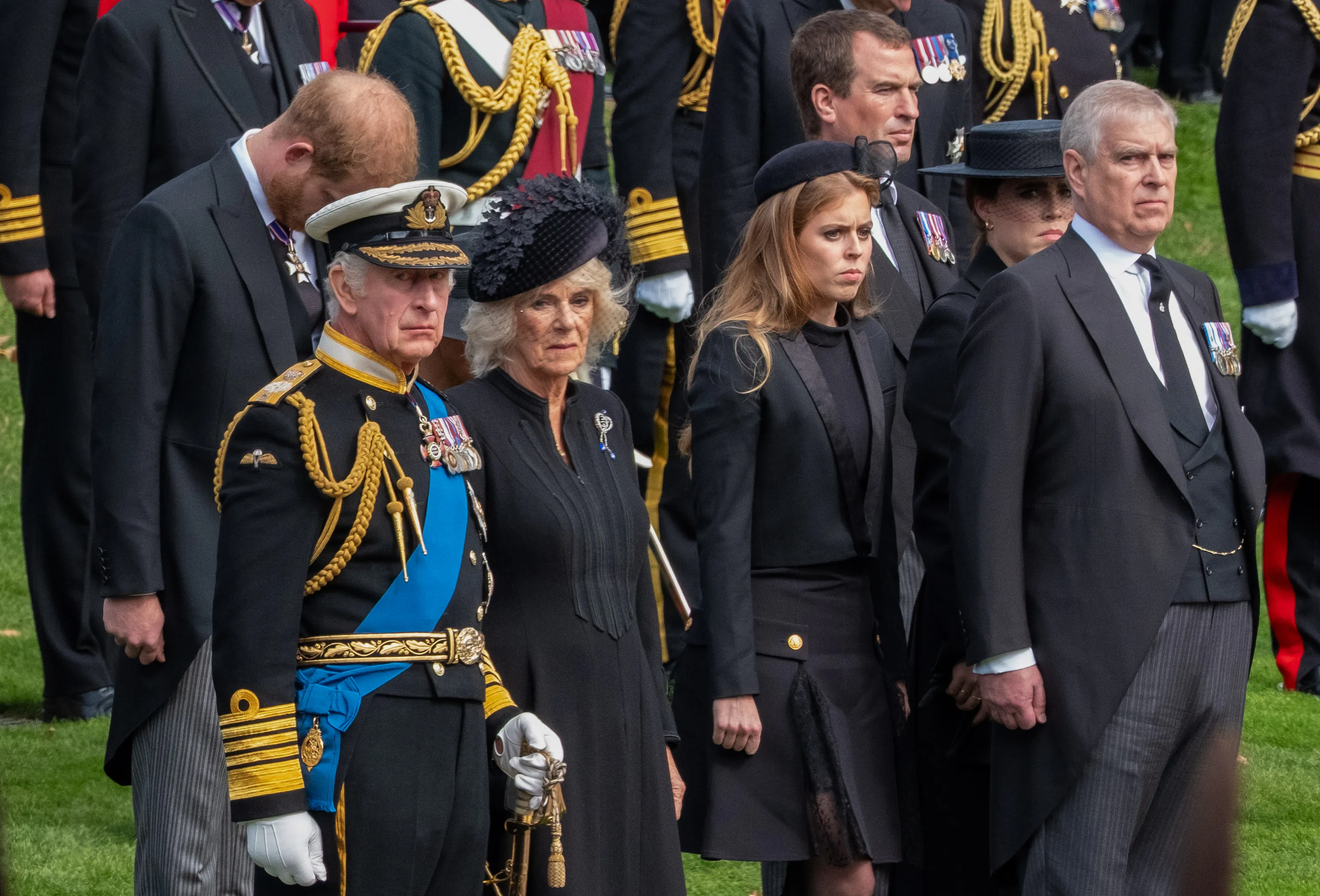 King Charles III in military uniform, Camilla Queen Consort, Prince Harry, Prince Andrew, Princess Beatrice, Princess Eugenie, and Peter Phillips at Queen Elizabeth II's state funeral procession.