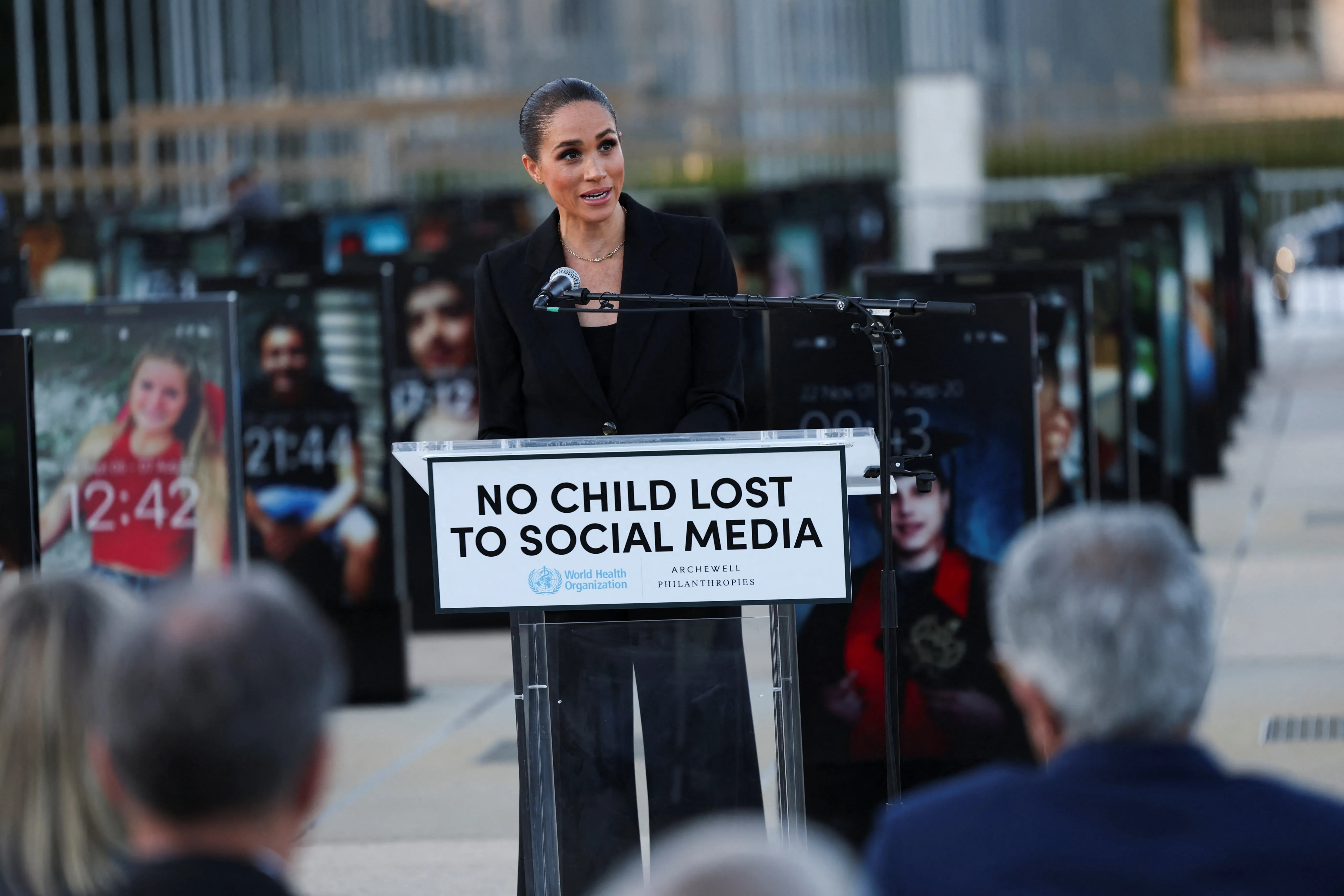 Meghan, Duchess of Sussex, speaks at a podium with a sign that reads