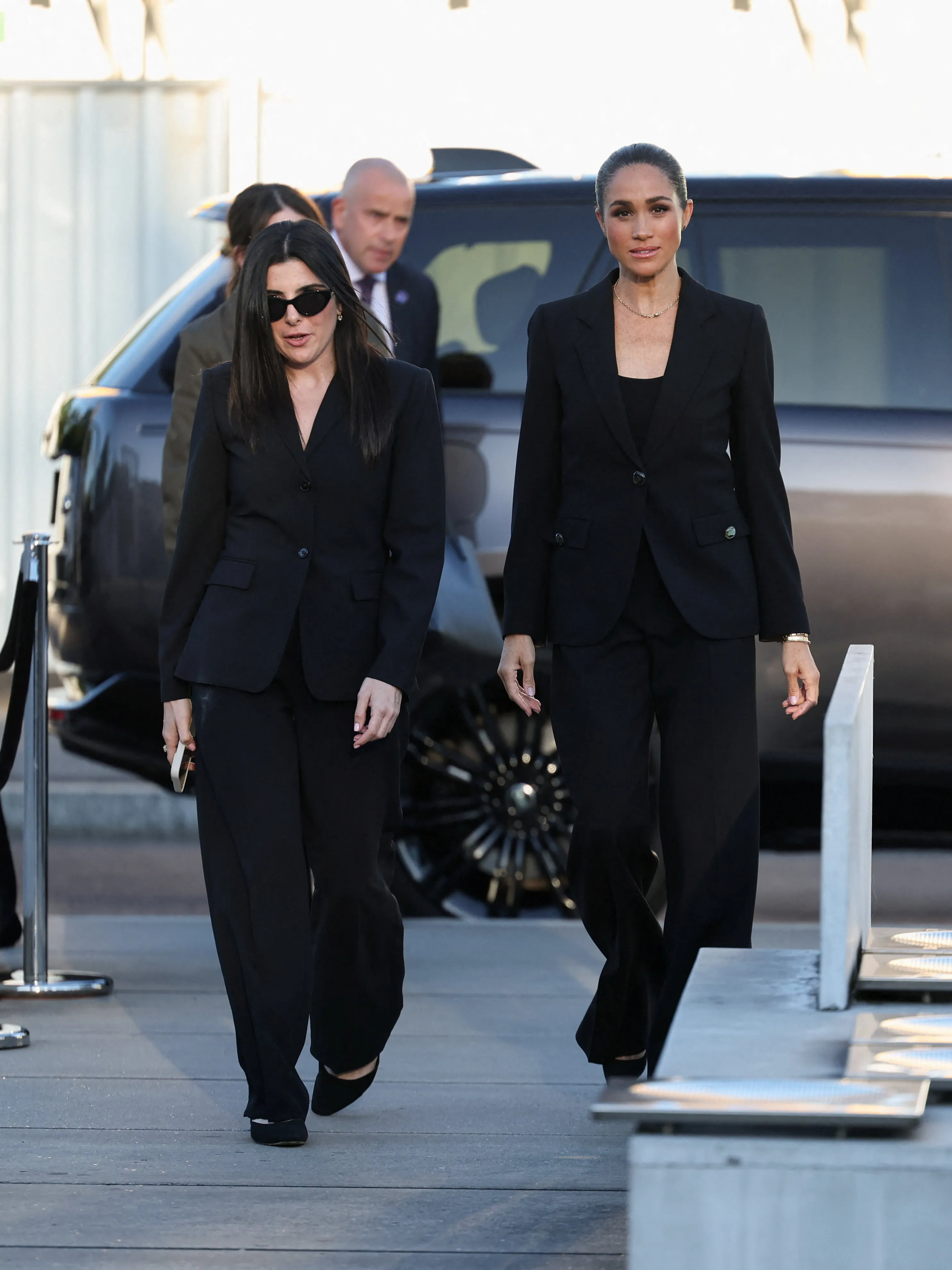 Meghan, Duchess of Sussex, in an all-black pantsuit, walking to attend the inauguration of the Lost Screen Memorial.