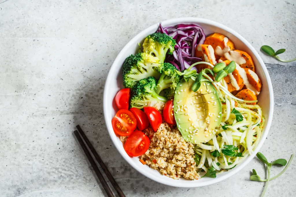 Buddha bowl salad with quinoa, avocado, broccoli, sweet potato, and tahini dressing.