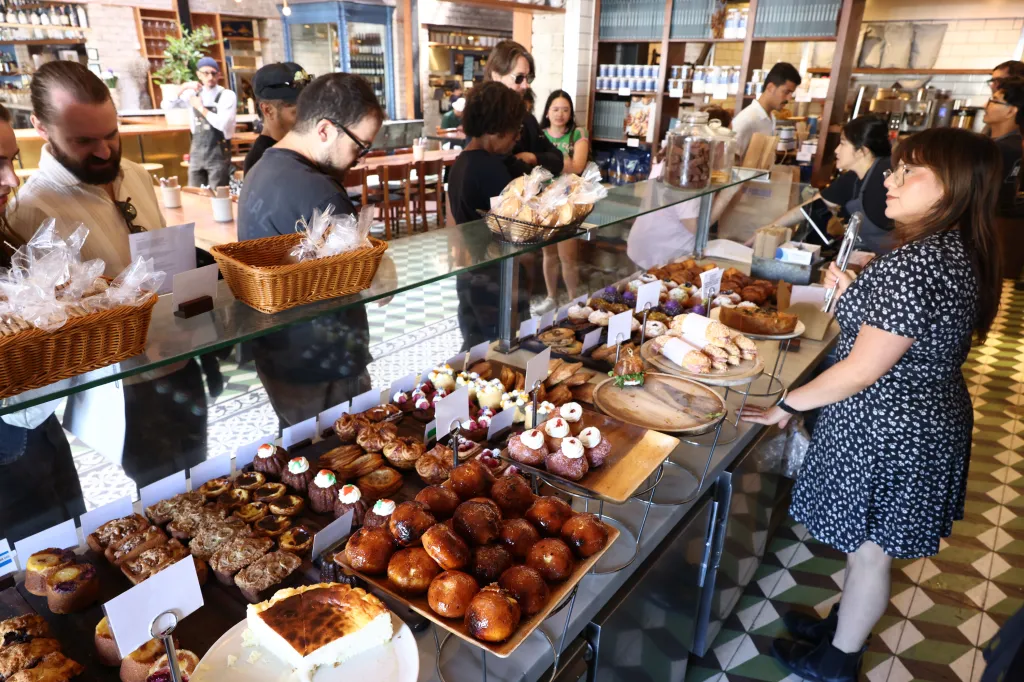 Christine Perez, cafe manager at République, stands behind a display case filled with pastries and baked goods.