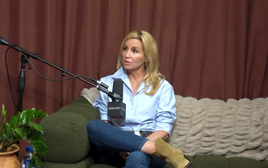 Camille Grammer seated on a couch in an interview setting.