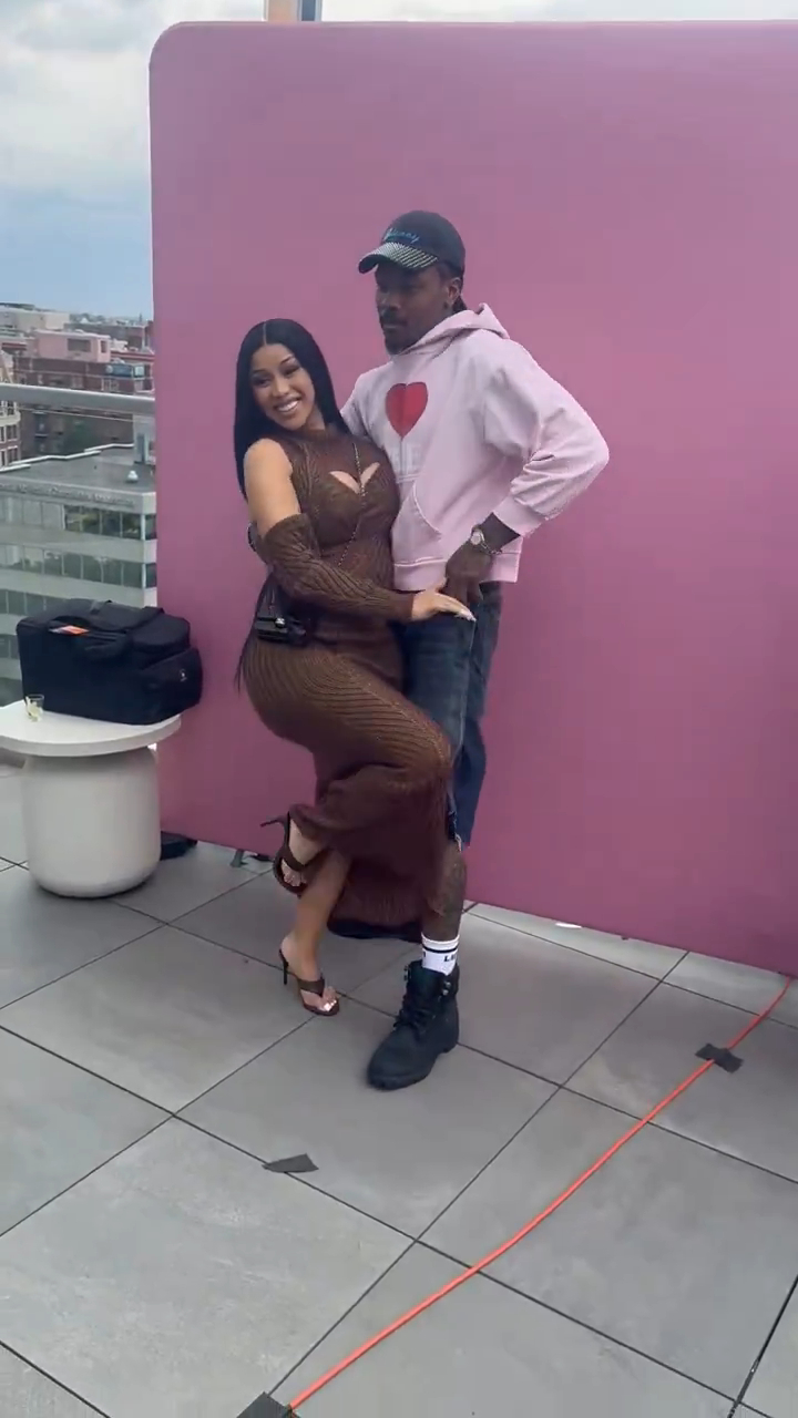 Cardi B and Stefon Diggs pose together on a rooftop.