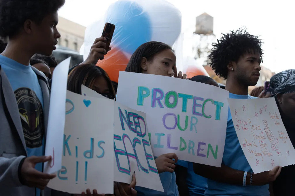 Young activists hold posters reading 