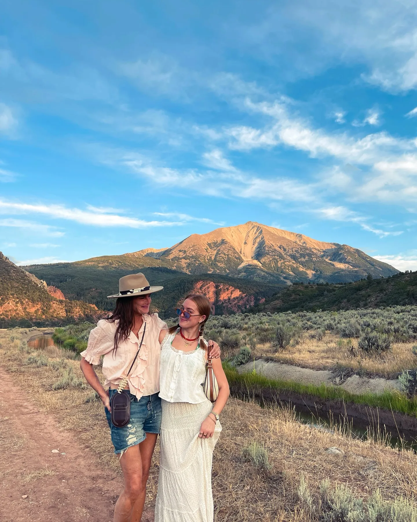 Brooke Shields and Rowan Henchy posing outdoors in front of a mountain landscape.