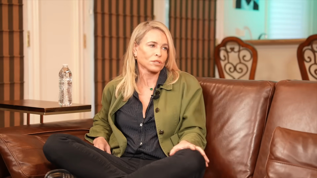 Chelsea Handler sitting on a brown leather couch.