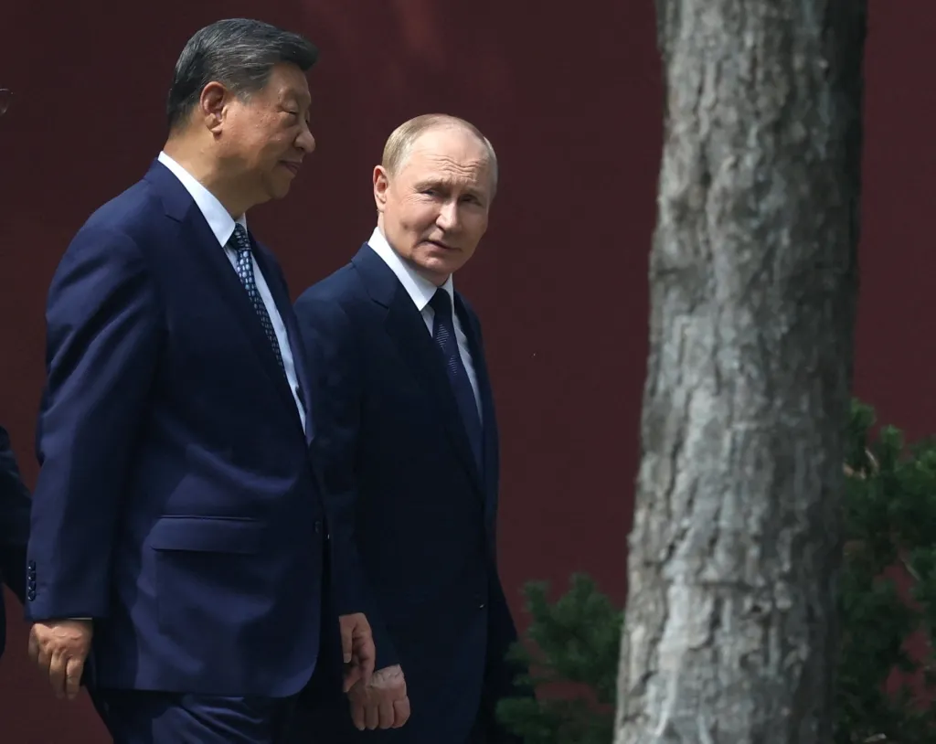 Chinese President Xi Jinping and Russian President Vladimir Putin walk in Beijing.