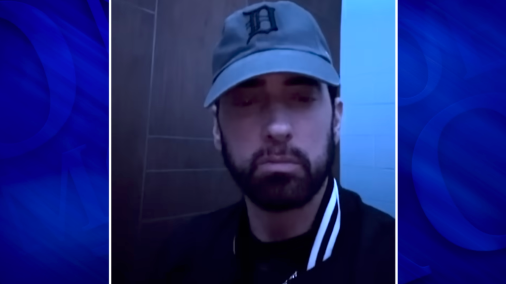 Rapper Eminem wearing a baseball cap with a black jacket.