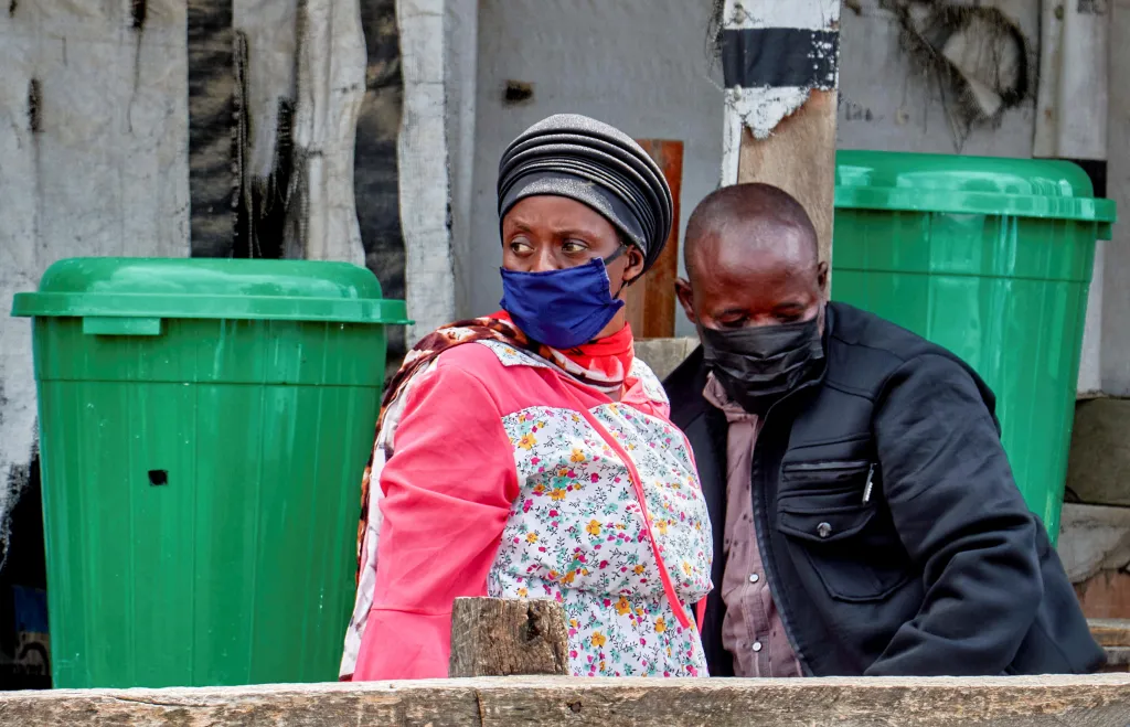 Two Congolese people wearing face masks mourn the death of an Ebola victim in Bunia, Ituri province.