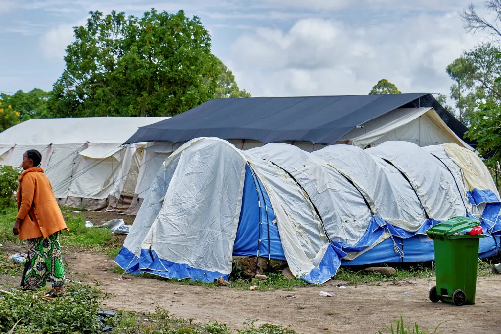 A Congolese woman walks past an Ebola treatment center made of several tents.