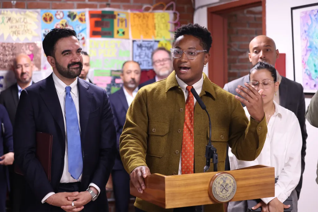 Councilmember Chi Ossé speaking at a podium while Mayor Zohran Mamdani stands beside him.