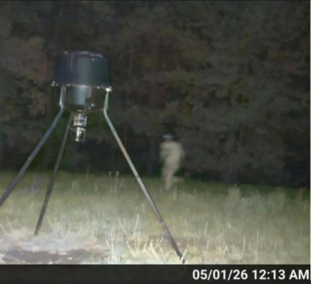 Trail camera capturing a blurry image of Craig Berry at night.