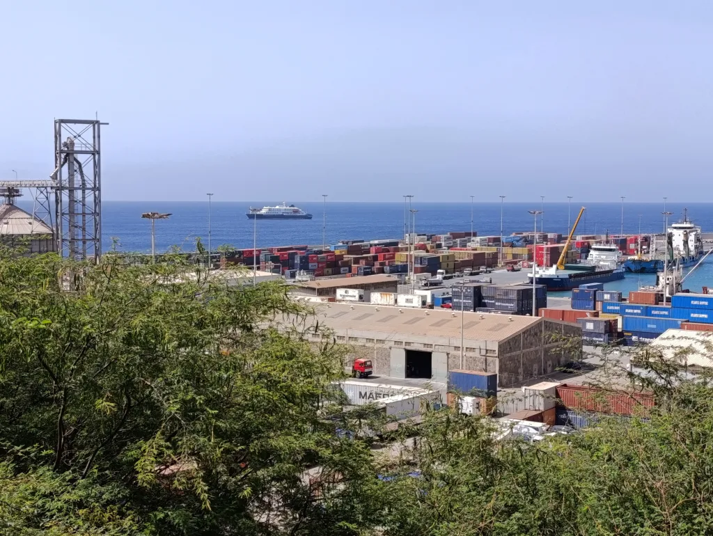 MV Hondius cruise ship docked off the Cape Verde port, with containers and cargo ships filling the port.