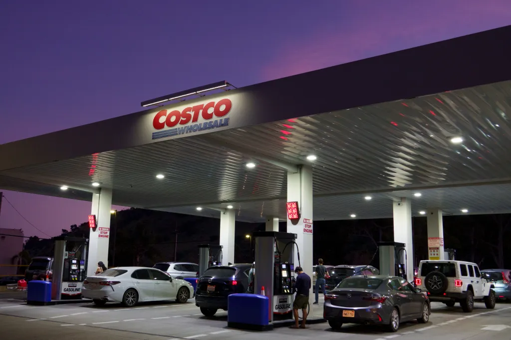 Customers pump gasoline at a Costco Wholesale gas station.