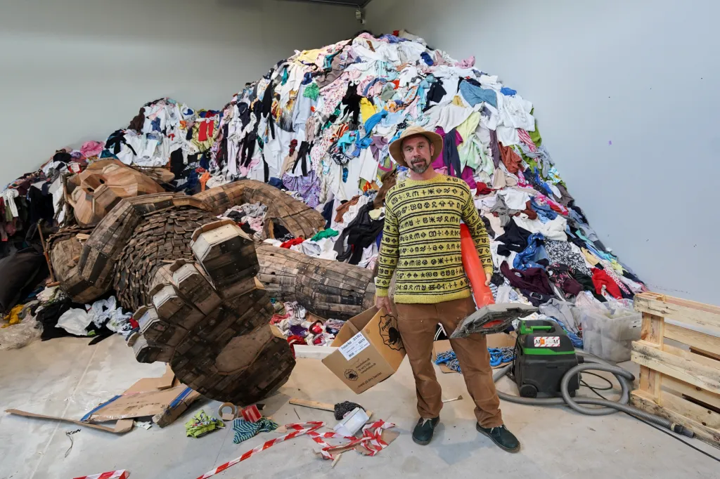 Thomas Dambo poses with his garbage art exhibition, 