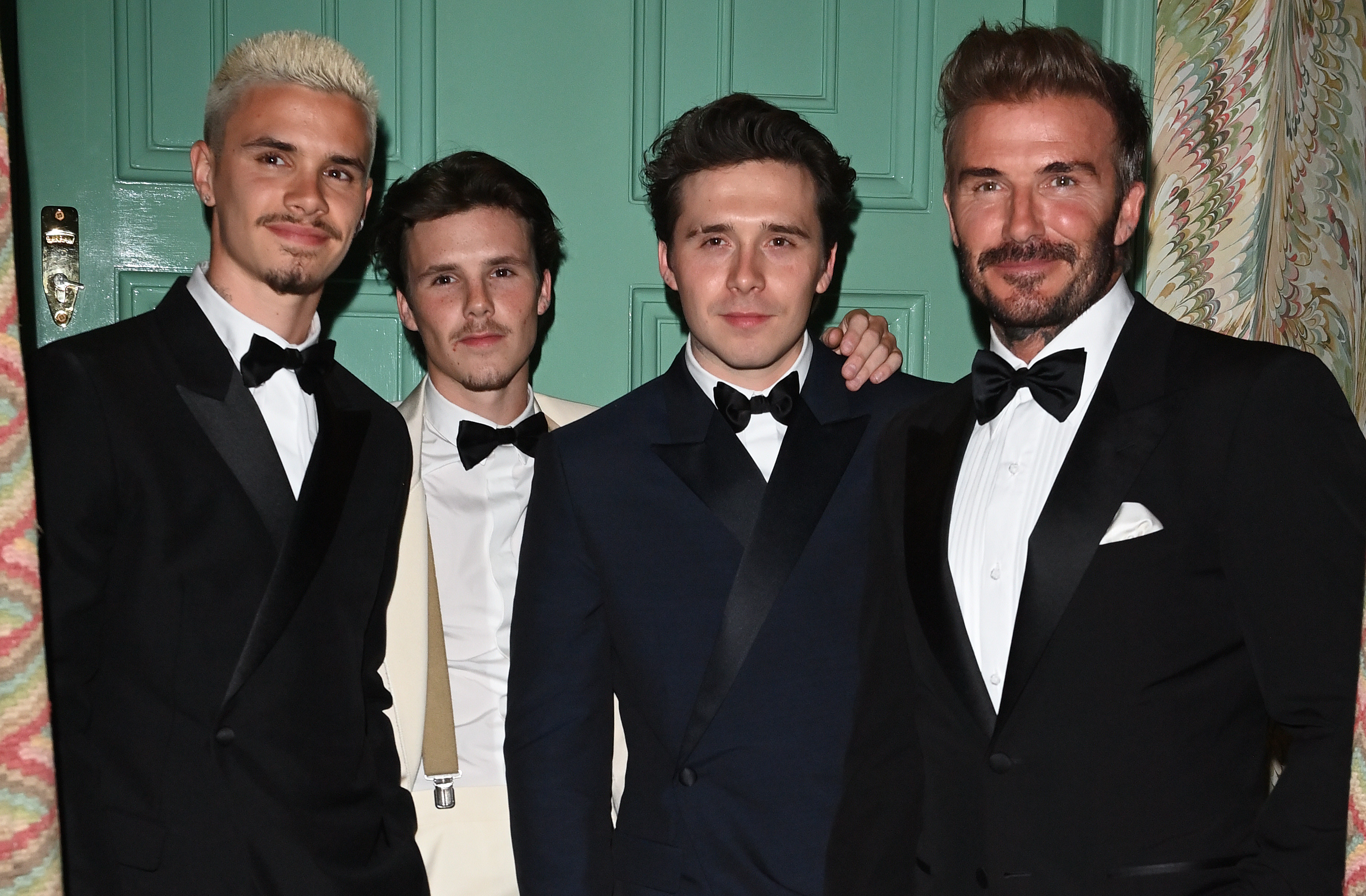 David Beckham with his sons Brooklyn, Romeo, and Cruz in formal wear.