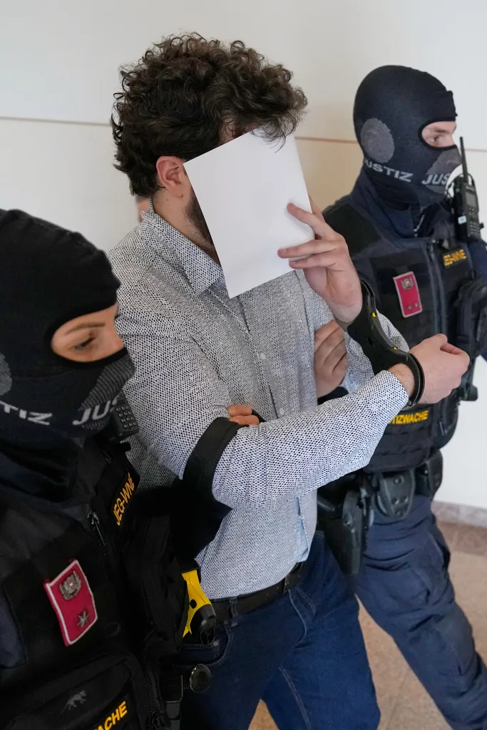 Defendant Beran A. wears a new shirt as he is returned to the courtroom in the District Court in Wiener Neustadt, Austria, where he stands trial for plotting to carry out an attack on one of superstar singer Taylor Swift's concerts in Vienna in August 2024 and pledging allegiance to the Islamic State group, Tuesday, April 28, 2026.