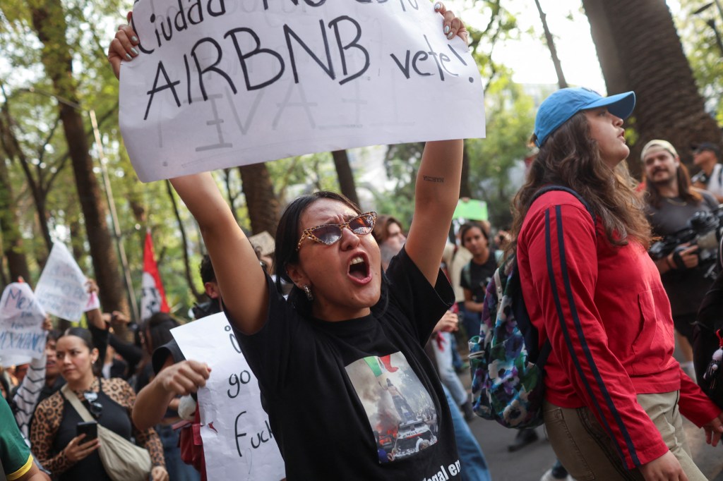 A protestor holds a banner reading 