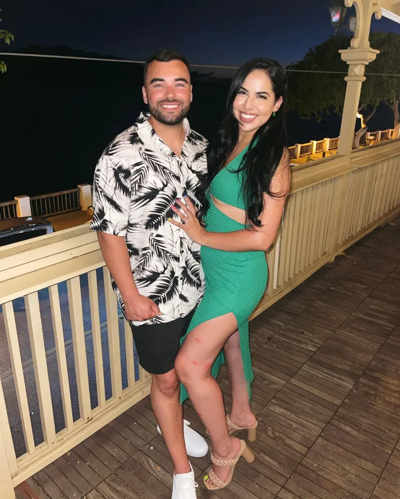Desiree Paula Noelle and Max Austin Mooney posing together outdoors at night.