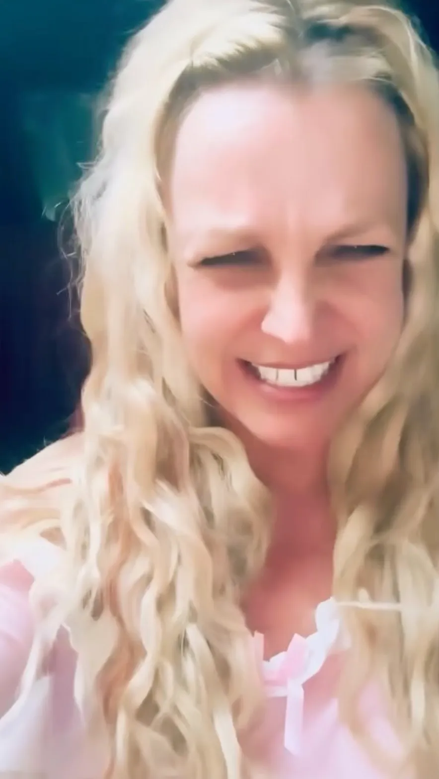 Britney Spears smiling excitedly with her eyes squinted.