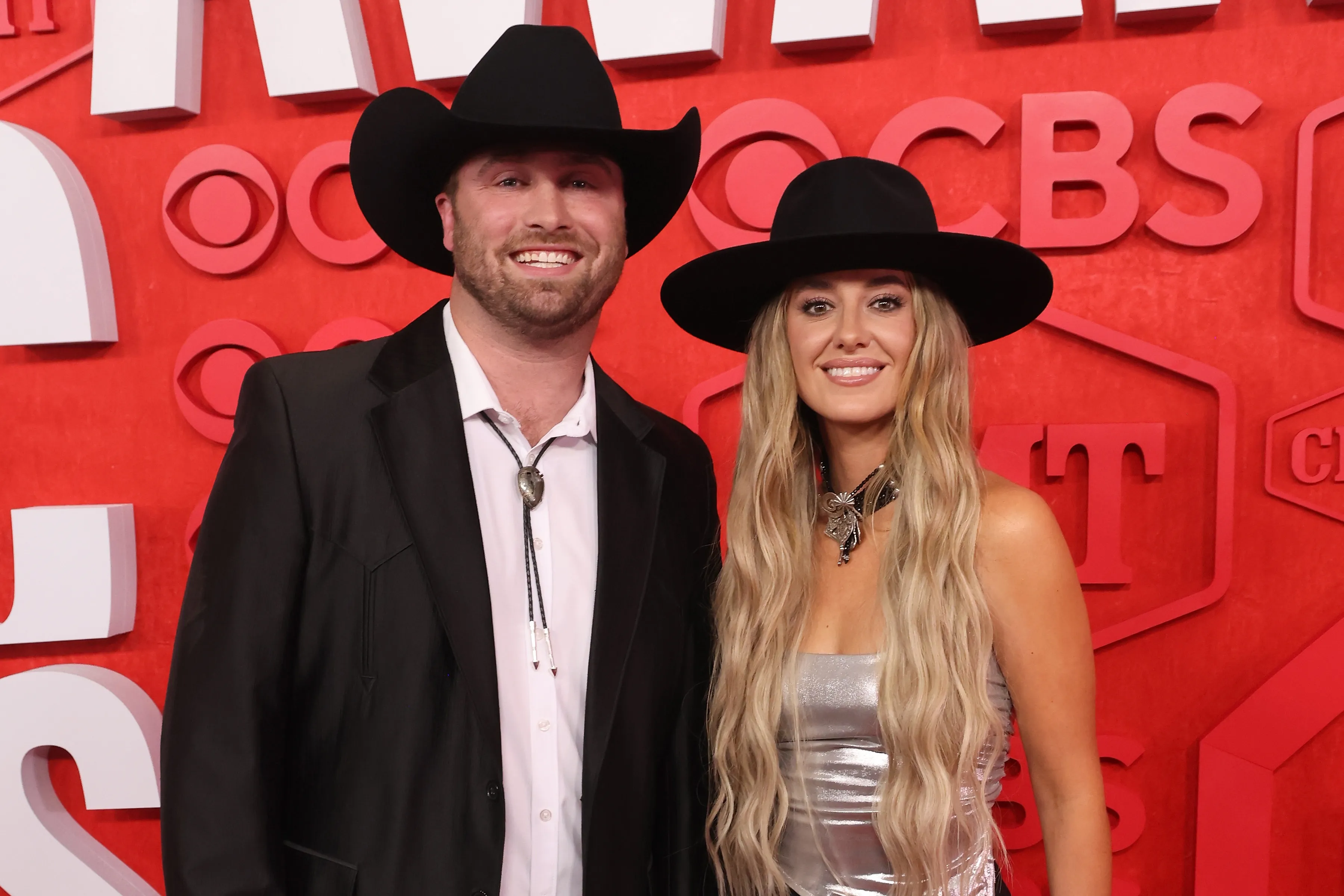 Devlin Hodges and Lainey Wilson pose together on the red carpet.