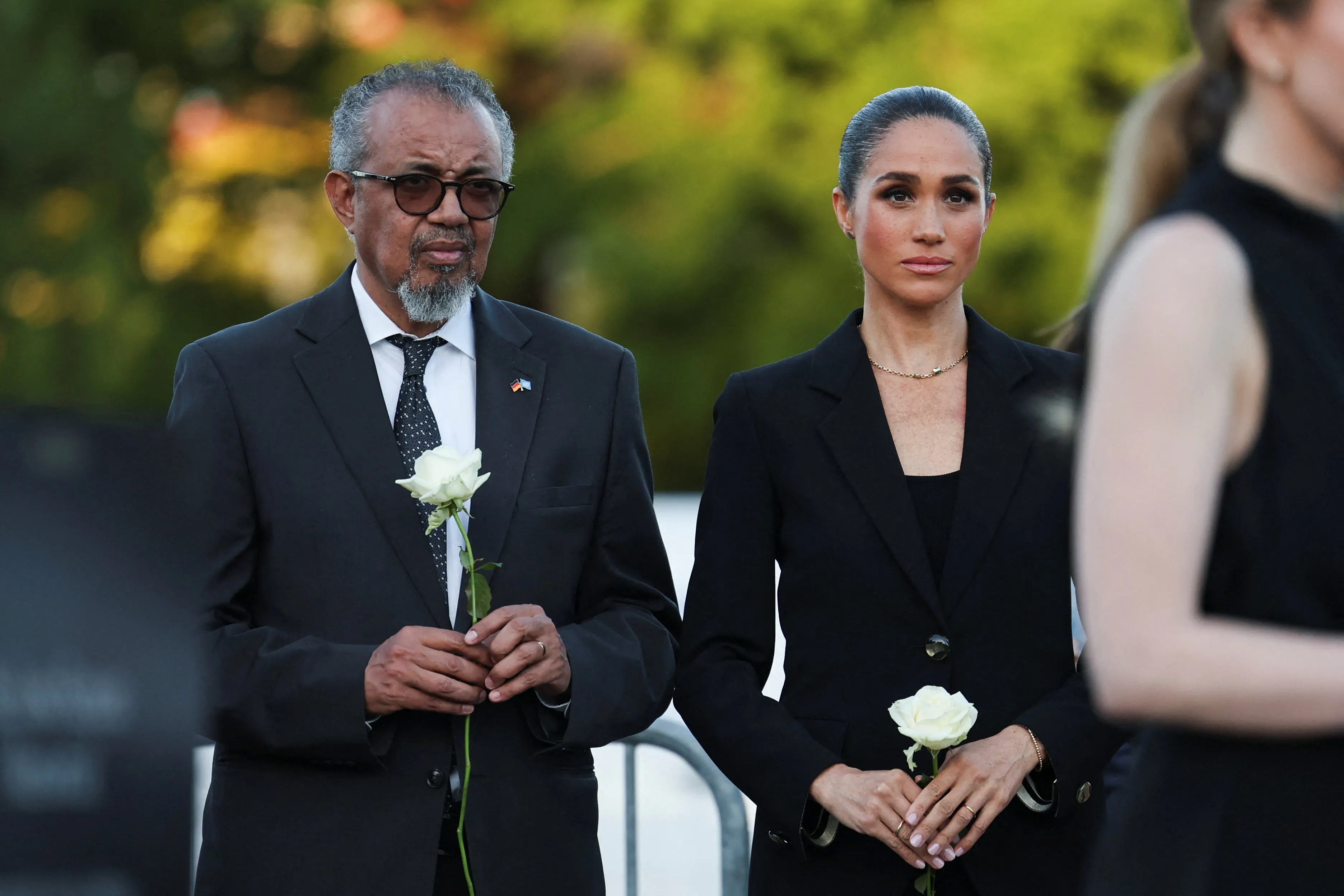 Meghan, Duchess of Sussex, and WHO Director-General Tedros Adhanom Ghebreyesus holding white roses at the Lost Screen Memorial in Geneva.