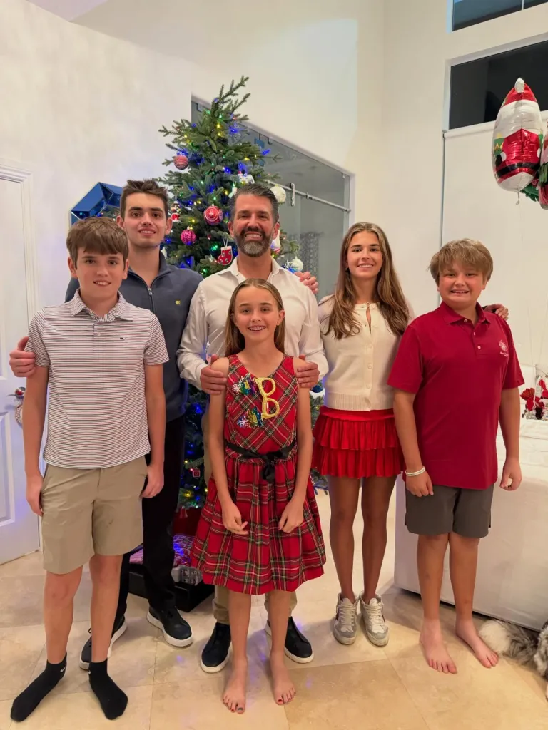 Donald Trump Jr. and his five children pose in front of a Christmas tree.
