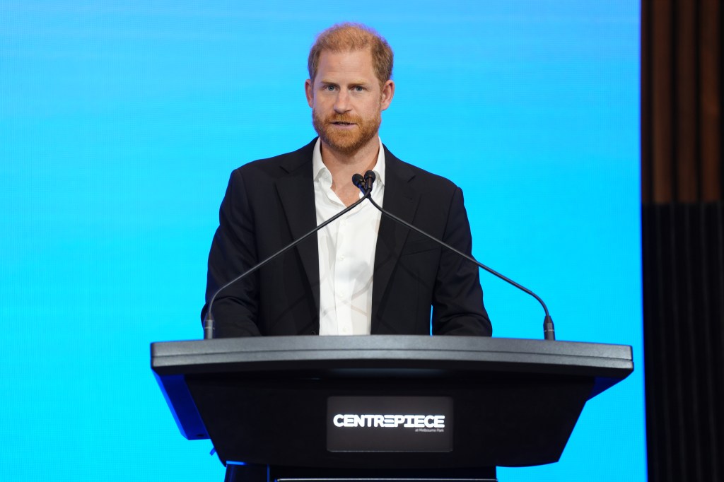Prince Harry, in a black suit and white shirt, giving the keynote speech at the InterEdge Summit.