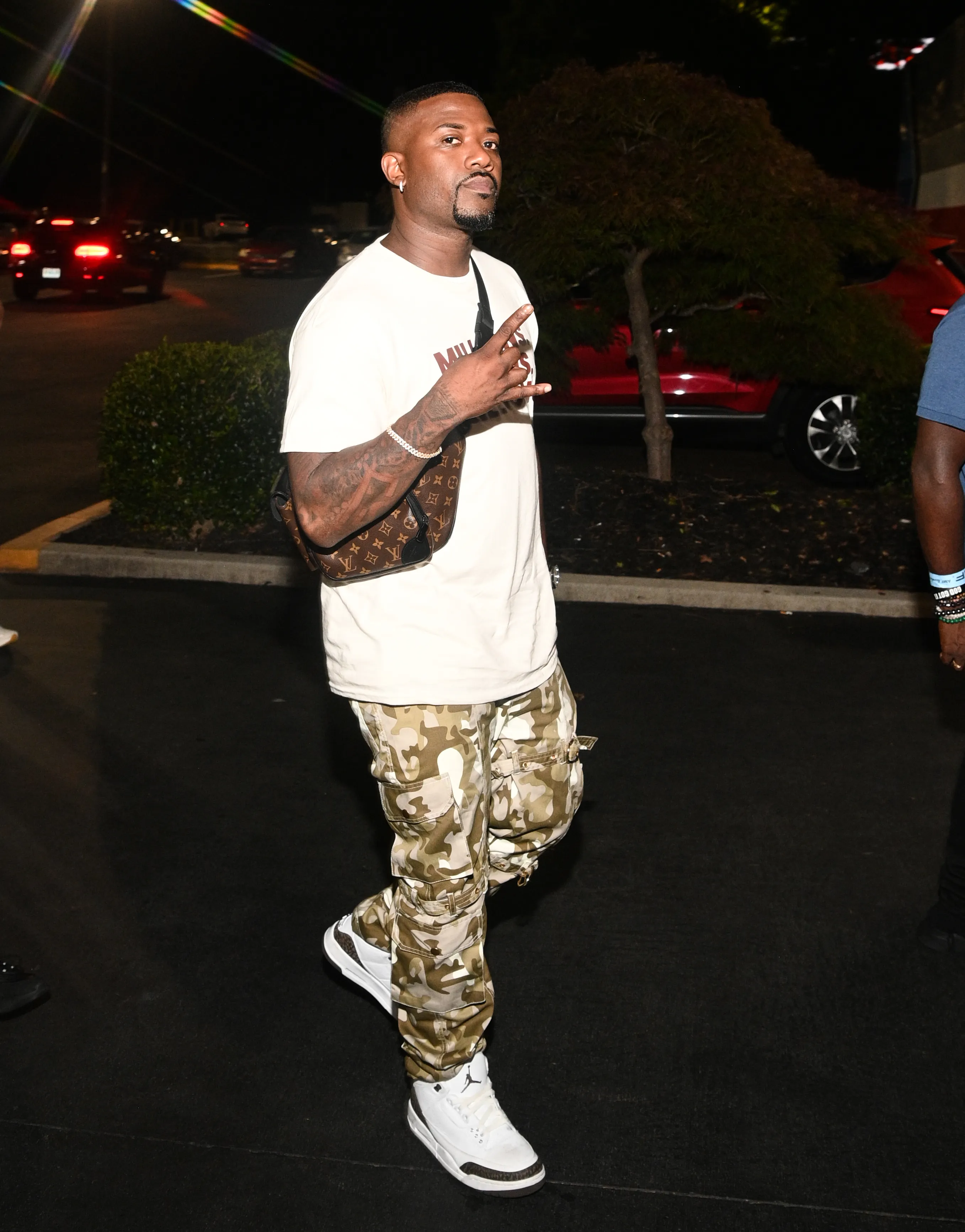 Ray J posing with a lens flare over his head and in the background.